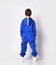 Full length rear view of a little preschooler or schoolboy in a warm blue sports suit.