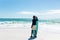 Full length of retired senior african american man standing with surfboard on shore at beach