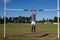 Full length of rugby player hanging on goal post at field