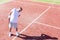 Full length of senior man standing with backache on red court during match on sunny day