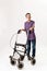 Full length shot of happy teenaged disabled boy with cerebral palsy smiling at camera, taking steps with his walker