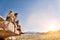 Full length shot of thoughtful rock climbers sitting on rock against clear blue sky