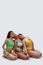 Full length shot of three diverse young women in colorful underwear posing together, leaning on each other, sitting on