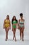 Full length shot of three serious diverse women with different body shapes in colorful underwear walking towards camera