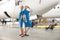 Full length shot of two pretty air stewardesses in bright blue uniform smiling at camera, posing together in front of