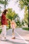 Full Length shot of woman supporting girl riding skateboard in the park