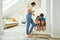 Full length shot of a young mother helping kids with homework at home, brother and sister sitting on stairs and studying