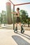 Full length shot of young sportswoman in kangoo jumping shoes exercising with punching bag, having workout at street gym