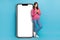 Full length size photo of modern gadgets user woman hold smartphone near huge display menu dating advert web panel