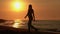 Full length slim woman in summer short dress, high boots spinning around on sandy beach at sunrise