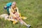 Full length of thoughtful female hiker sitting on grass