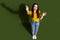 Full length top view photo of charming positive woman wear yellow shirt rising arms empty space isolated khaki color