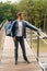 Full length vertical portrait of handsome young male of food delivery service with large thermal backpack standing on