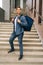 Full length vertical portrait of smiling handsome young male of food delivery service with large thermal backpack