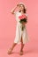 Full-length vertical shot gorgeous elegant woman in dress and hat, going home from date, holding beautiful flowers