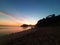 Full length view through the sandy beach with golden sea water at sunset