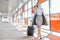 Full length of young businesswoman with luggage walking in railroad station