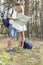 Full length of young hiking couple reading map in woods