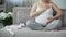 Full of maternal instincts woman gently touching her beloved pregnant tummy