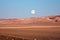 full moon above an isolated desert area