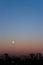 Full moon on clear sunrise sky and buildings under it