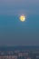 Full moon at dusk  above polluted city  of Belgrade