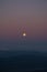 Full moon in the mountains during sunrise