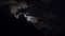 Full moon moves in the night sky through dark clouds. Time lapse