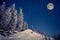 Full moon in the night sky in winter mountains