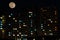 Full moon over colorful windows of residential house