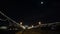 Full moon over a pier with Christmas lights