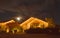 Full moon peaks over a home with Christmas lights