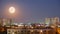 Full moon rise at blue hour over city scape. Copy space