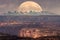 Full moon rising behind La Sal Mountains in Canyonlands National Park during sunset