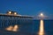Full moon rising at a fishing pier