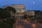 Full moon rising over the Colosseum or Roman Coliseum at dusk with streaked car lights, originally the Flavian Amphitheatre, an el