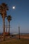 Full moon rising over sand mounds.