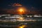 Full moon rising over sea waves. Dramatic sunset over beach