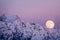 Full moon rising over a winter mountain landscape