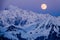 Full moon rising over a winter mountain landscape