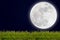 Full moon with stars and field of green hill on darkness sky.