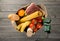 Full paper bag of different groceries on wooden background