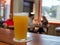 Full pint glass of IPA beer sitting on wooden table at brewery restaurant with people in background