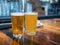 Full pint glasses of ale and golden beers sitting on bar counter