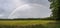 Full rainbow panorama against dark clouds