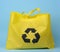 Full reusable yellow viscose bag on blue background