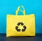 Full reusable yellow viscose bag on blue wooden background