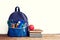 Full School Backpack with books and apple on white background.