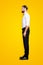 Full size fullbody half face portrait of handsome trendy croupier in white shirt, bowtie, black pants, formalwear