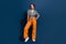 Full size photo of attractive young woman posing model dressed stylish flared pants jeans clothes isolated on dark blue